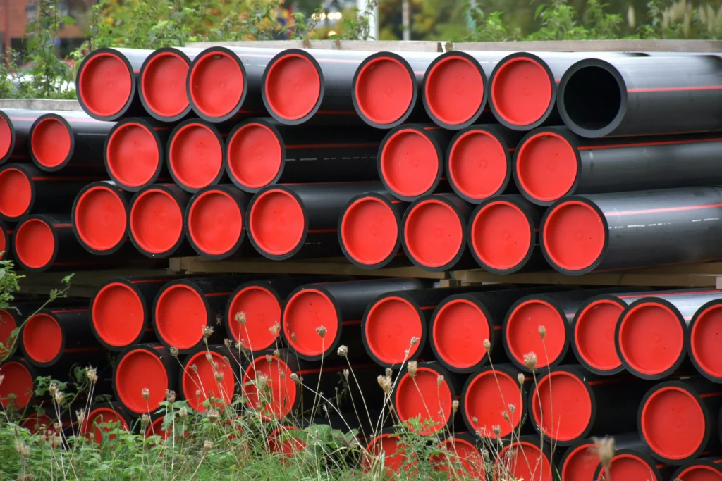 Składowane rury z PVC przygotowane do zastosowań przemysłowych, wykorzystywane w instalacjach pracujących w środowisku chemicznym.